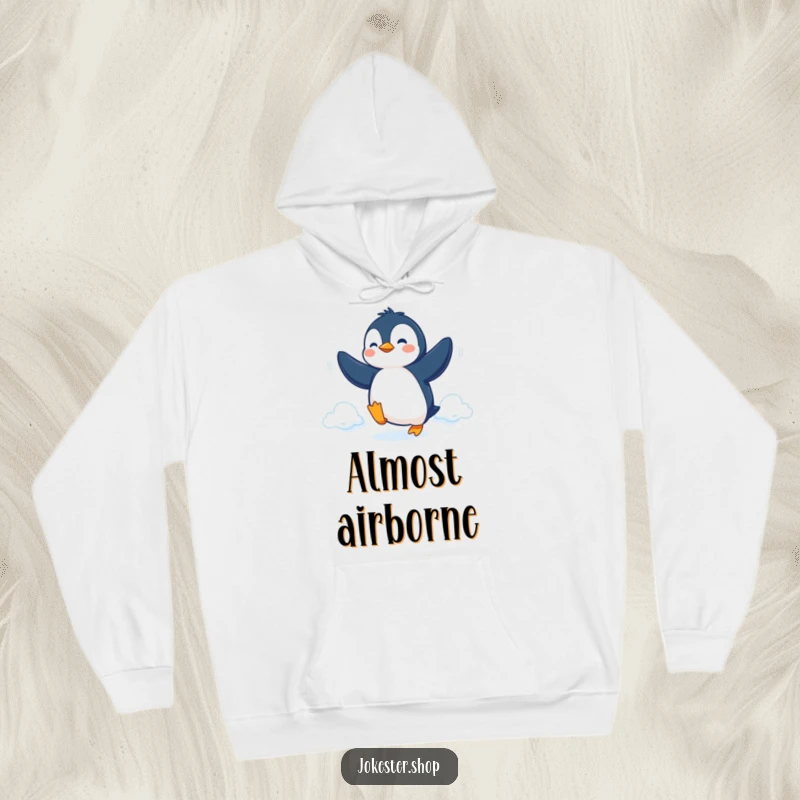 Funny Hoodie featuring a determined penguin attempting flight with flippers, offering cozy inspiration and humor.