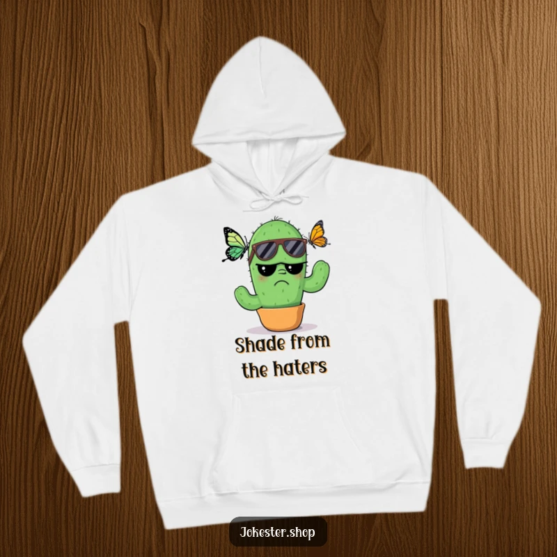 Funny Hoodie: A grumpy cactus wearing cool sunglasses, looking annoyed by a butterfly, providing a warm and humorous layer of personality.